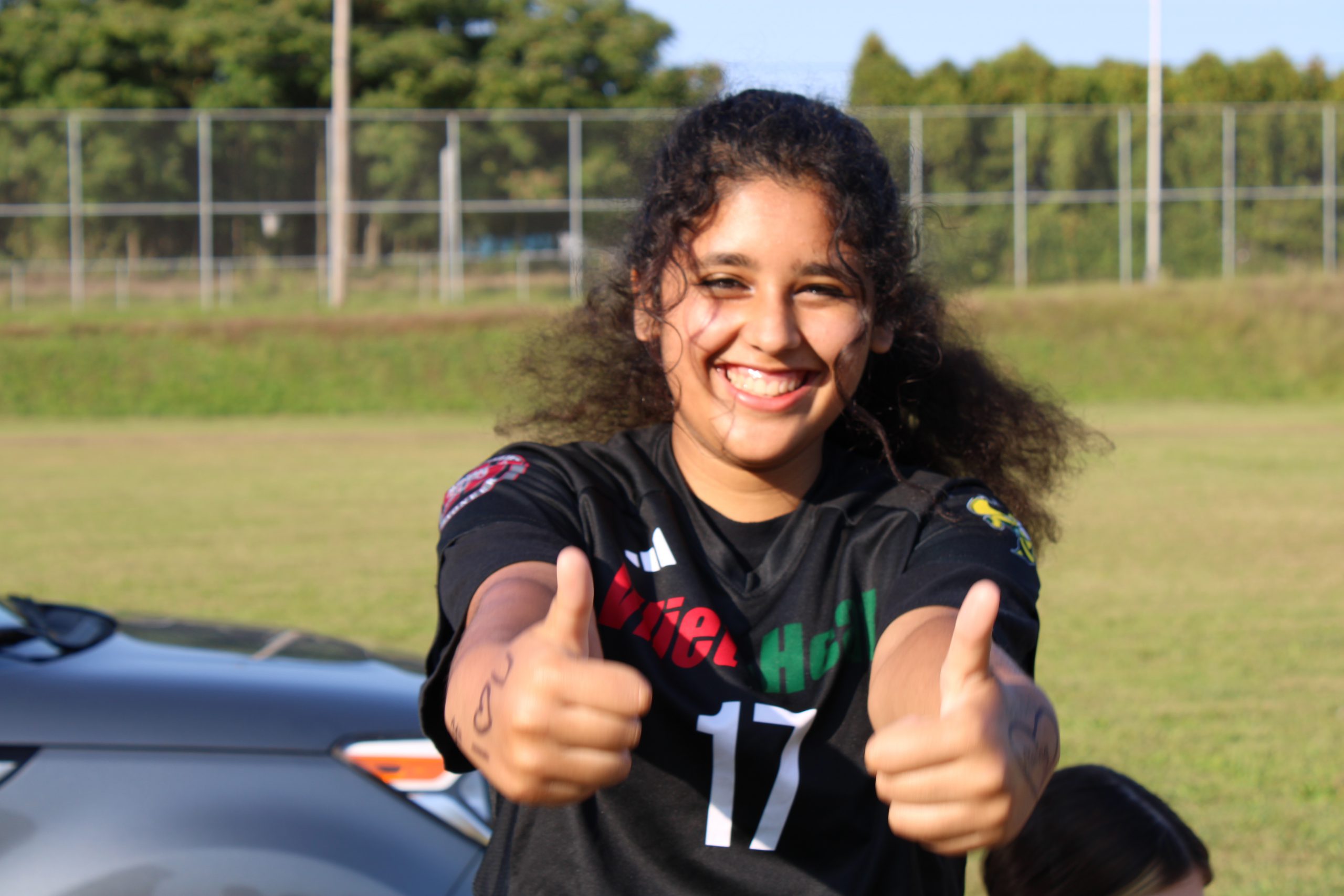 Girl in Soccer Uniform looking at camera with two thumbs up